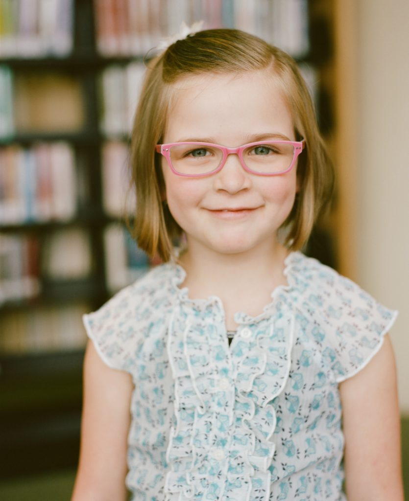 Children's glasses - girl wearing pink framed glasses